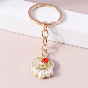 Fashionable golden keychain with red rose pendant, shiny rhinestones and elegant white pearls