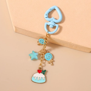 Dettaglio di portachiavi blu a tema dessert con chiusura a cuore e ciondoli a stella