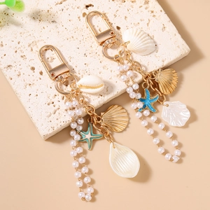 Ocean theme keychain featuring golden starfish, shells, and white pearl tassels on stone