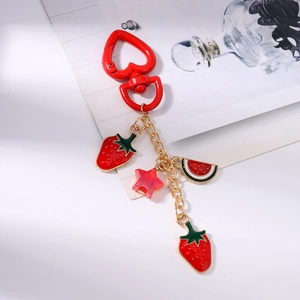 Dettaglio dei ciondoli a fragola e anguria su un portachiavi rosso a forma di cuore