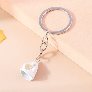 Dettaglio di portachiavi a fantasma bianco con cuore dorato e anello in metallo