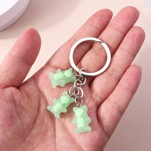 Detail of three light green translucent bear charms with skull patterns on a silver keychain