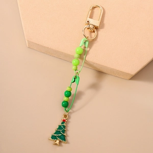 Detailed view of a green Christmas tree keychain with beaded pins and golden lobster clasp