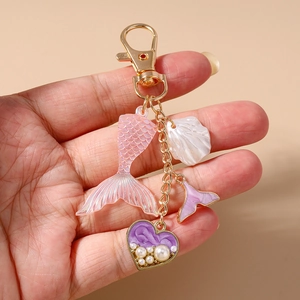 Detail of ocean-themed keychain with pink mermaid tail and pearl heart charm
