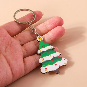 Detailed view of hand-held colorful Christmas tree keychain with silver metal ring