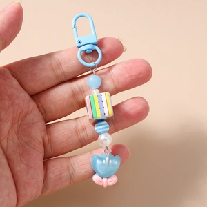 Dettaglio del portachiavi a tulipano blu con perline e fiocco rosa decorativo