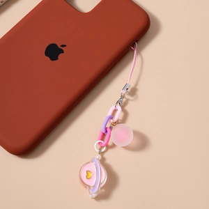 Pink and purple planet charm chain with heart detail on a mobile phone case