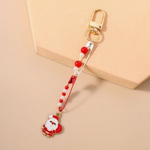 Detail of Christmas keychain with safety pins, red and white beads and Santa Claus charm