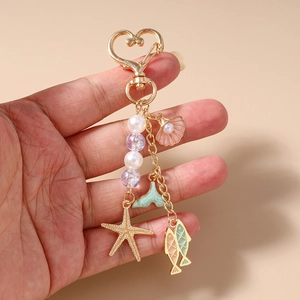 Ocean-themed beaded keychain with starfish and shell charms held in hand