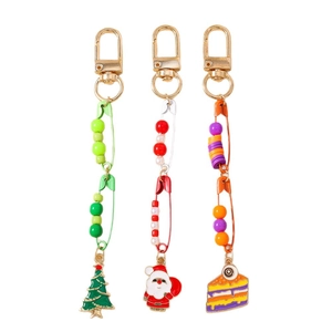 Three Christmas keychains with Santa, Xmas tree, and eyeball cake charms and colorful pins