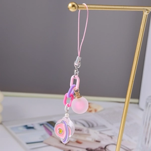 Macro detail of a pink planet charm with heart pattern and colorful chain links