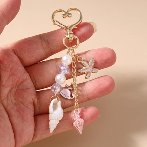 Ocean themed keychain with gold heart clasp, pearls, starfish, and pink whale charms