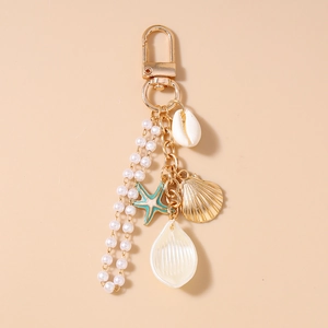 Detail of ocean theme keychain with gold starfish, shell, pearl and flower pendants