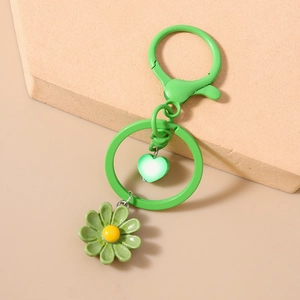 Dettaglio del portachiavi a margherita verde con ciondolo a cuore su anello in metallo