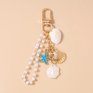 Detail view of ocean-themed keychain with gold alloy shells, blue starfish, and pearl chain