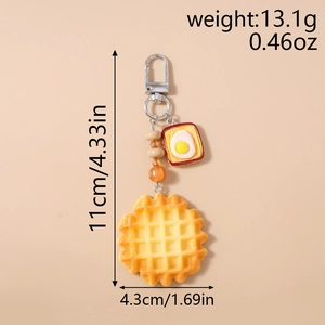 Detail view of waffle and egg toast food keychain with dimensions 11cm by 4.3cm