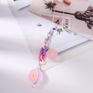 Detail of candy-colored chain bag charm with planet pendant and pink matte bead
