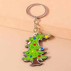 Detail of colorful cartoon Christmas tree keychain with silver metal ring on warm beige background