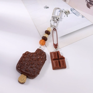 Dettaglio portachiavi con perline, gelato al cioccolato e ciondolo barretta di latte