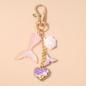 Detailed close-up of a mermaid shell keychain with pearls and gradient fish tail charm