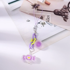 Close-up of purple candy-shaped pendant with heart detail on chunky chain strap