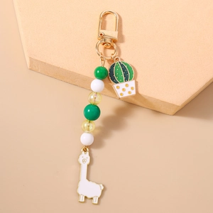 Detail of keychain featuring gold clasp, green cactus, white alpaca and colorful beads