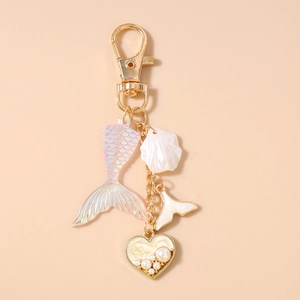 Detail of ocean-themed keychain featuring pearlescent fish tail and pearl heart charms