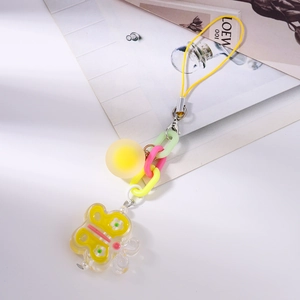 Detail view of colorful butterfly phone charm with yellow strap and clear resin pendant