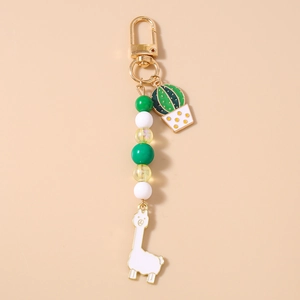 Close-up of beaded keychain featuring golden charms and cute cactus alpaca pendants