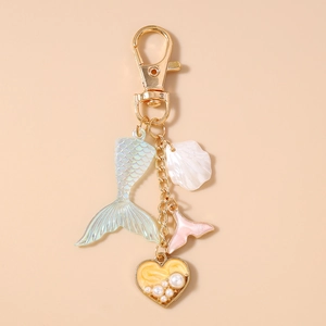 Detailed view of ocean-themed mermaid tail keychain with heart charms and faux pearls