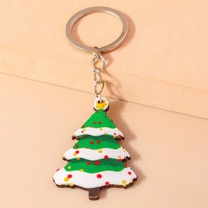 Detail of cartoon Christmas tree keychain with colorful dots and top star on beige steps