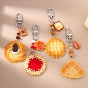 Close-up of realistic biscuit and waffle keychains with colorful beads and metal clasps