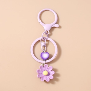 Dettaglio del portachiavi a margherita viola con ciondolo a cuore e moschettone