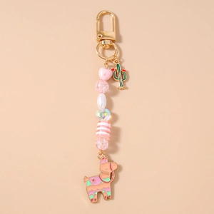Detailed close-up of a pink llama keychain with colorful beads and cactus charm