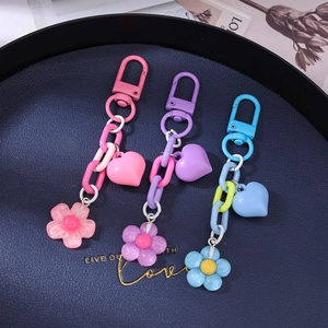 Detailed view of matte heart and translucent floral charms on colorful keychains