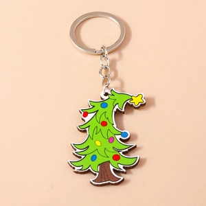 Detailed view of a green Christmas tree keychain with colorful dots on orange background