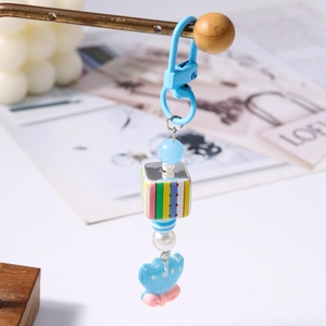 Dettaglio di un portachiavi a forma di gatto blu con catena spessa e perline colorate