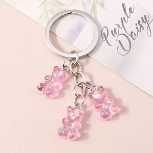 Detail of pink glitter resin bear pendants and silver metal keyring with floral card