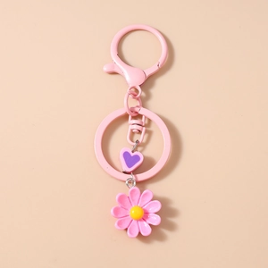 Dettaglio del portachiavi a margherita rosa con cuore viola e chiusura a moschettone