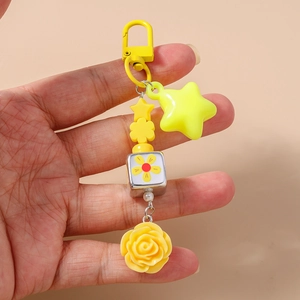 Detail of yellow flower cubes and star beads on a stylish resin keychain pendant