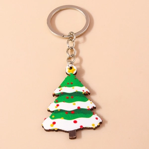 Close-up of green acrylic Christmas tree keychain with white snow details and silver metal ring
