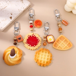 Beaded artificial food keychains featuring cookies and toast on a warm background