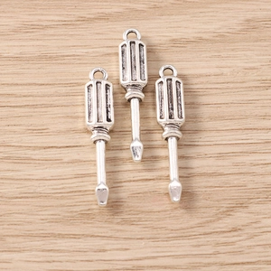 Macro detail of three silver alloy screwdriver charms for DIY jewelry making