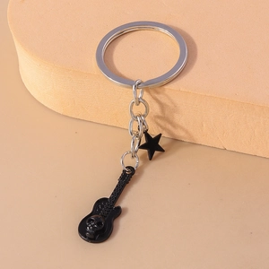 Punk style guitar and pentagram star keychain with skull relief on orange foam stand