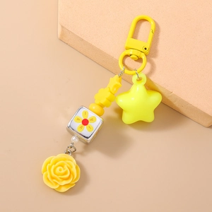 Detail view of yellow resin rose and star beads on a floral cube keychain charm