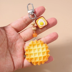 Detail of beaded keychain with realistic waffle and fried egg toast pendant charms