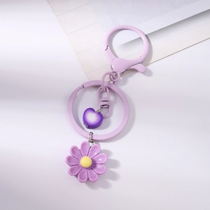 Dettaglio portachiavi margherita viola con ciondolo a cuore e chiusura a moschettone