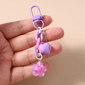 Detail of purple heart and cherry blossom keychain with colorful plastic chain and charms