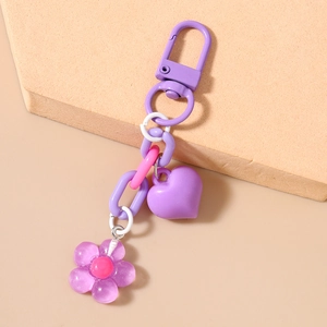 Detail of purple cherry blossom keychain with heart pendant and resin flower for bags