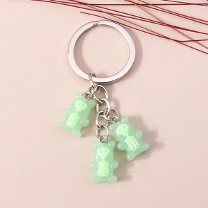 Macro detail of three mint green gummy bear charms with skeleton prints on a silver keyring